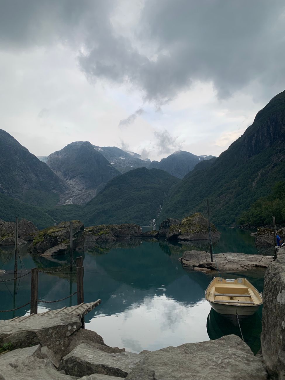 Misty fjord waters with traditional wooden boat in Norway